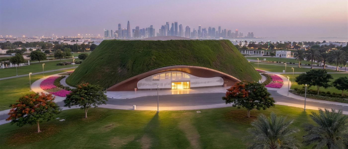 The Teen Hub pavilion at Al Bidda Park at dusk, the Doha skyline behind it.